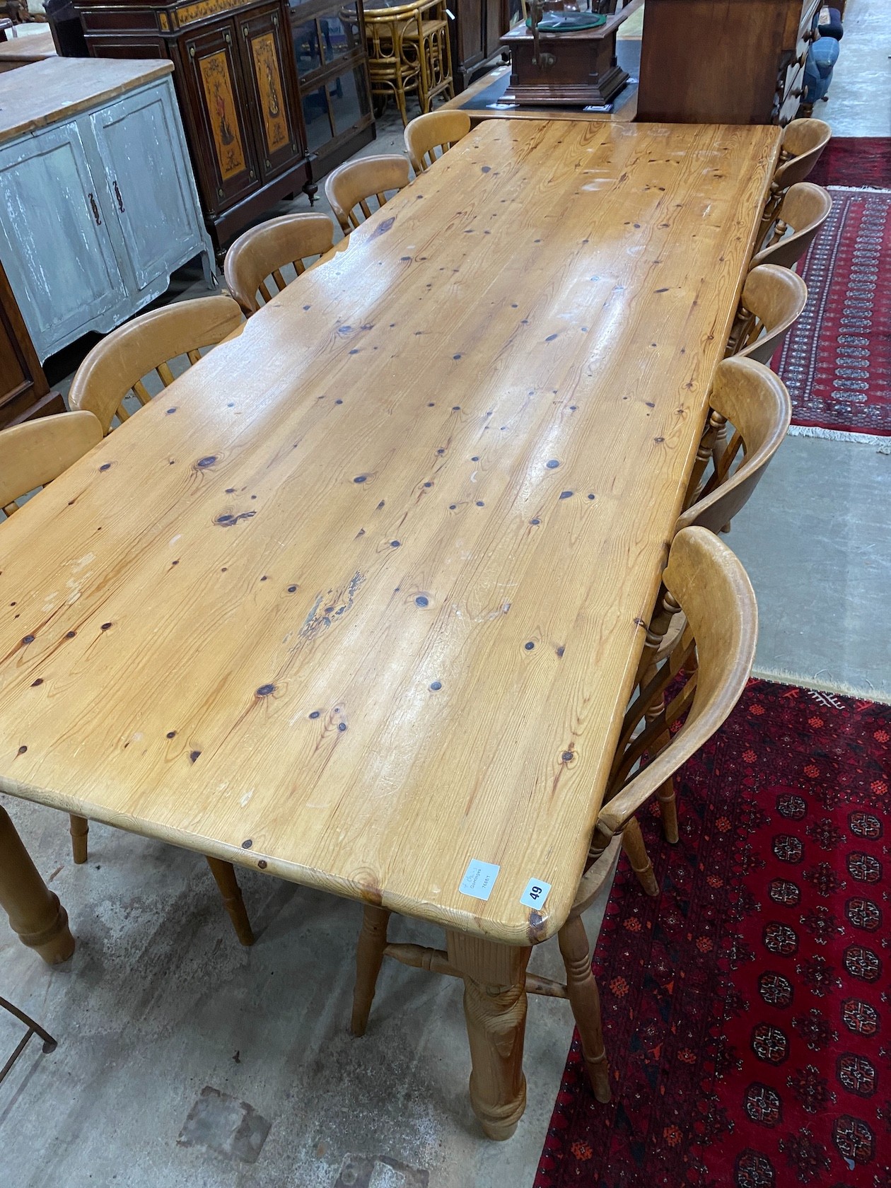 A large Victorian style rectangular pine kitchen table, length 305cm, depth 105cm, height 76cm and ten lathe back beech Windsor kitchen chairs